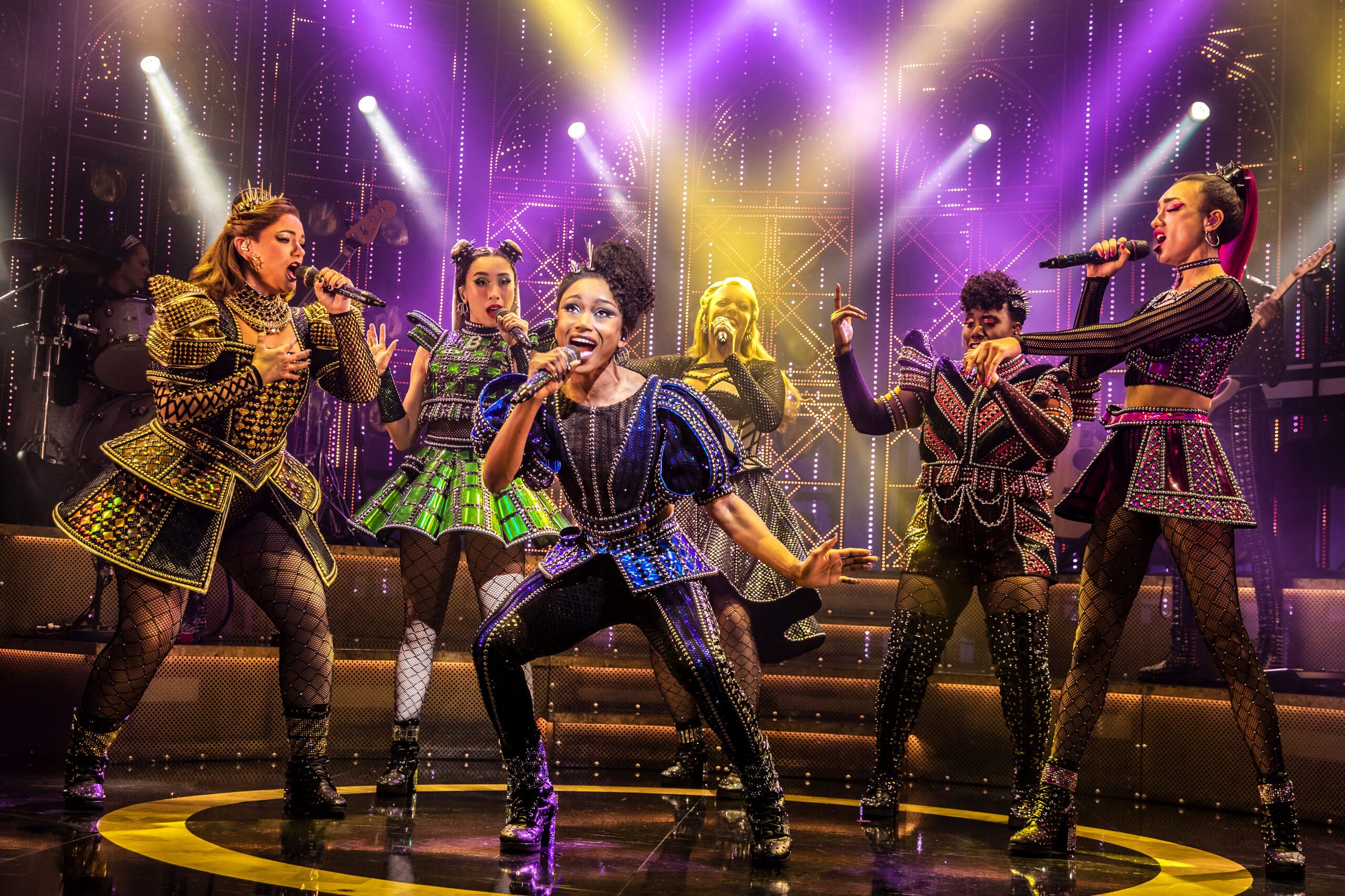 The cast of 'SIX: The Musical' singing on stage on the West End