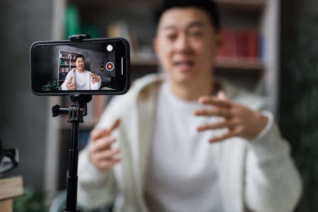 Man recording himself on a phone mounted on a tripod